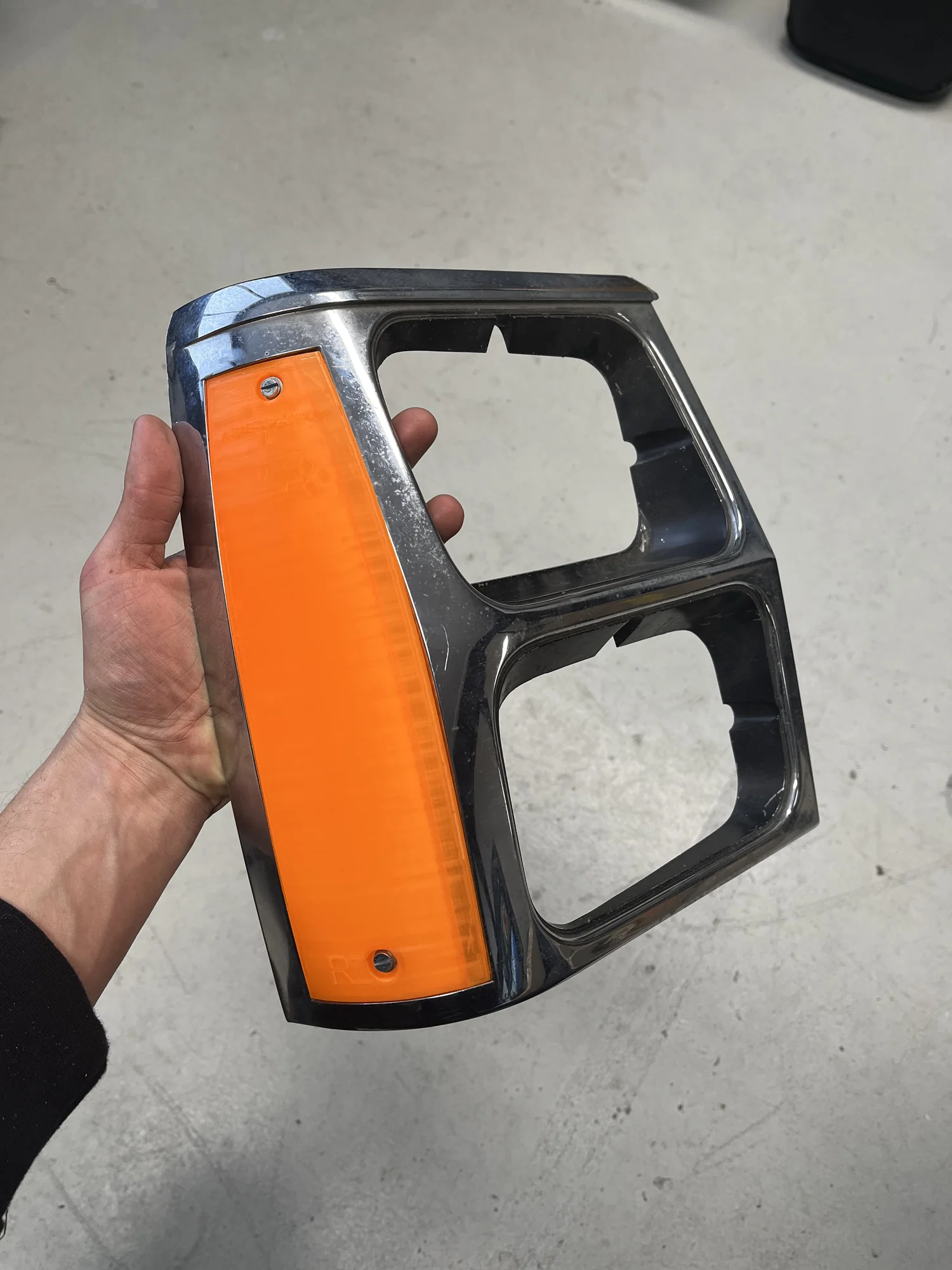 Een nieuw gemaakte oranje knipperlichtlens in de originele verchroomde rand van een Jeep Cherokee